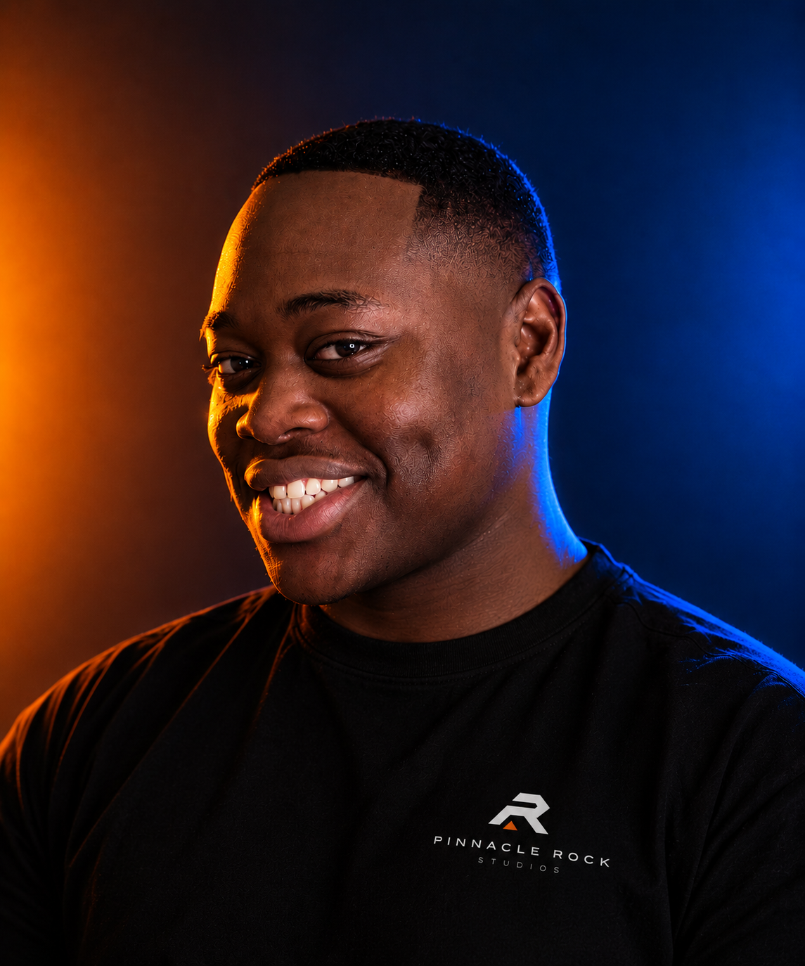 Pinnacle Rock Studios founder portrait in orange and blue studio lighting.
